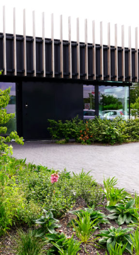 kantoorgebouw met beplanting en bomen